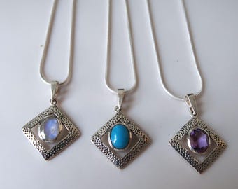 silver diamond shape pendant with oval cut gemstone