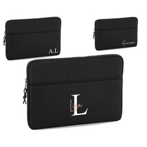 May include: Black laptop sleeve with a zip and a front pocket. The sleeve is personalised with the initials "A.L" and the name "Lisa" in a stylish font. A smaller sleeve is also shown with the name "Francesca".