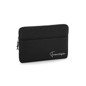 May include: A black laptop sleeve with a zipper closure and a small pocket. The name "Francesca" is written in a cursive font on the lower right corner of the sleeve.