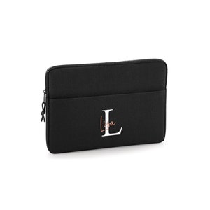 May include: Black laptop sleeve with a zipper closure and a front pocket. The sleeve features the name "Lisa" in a cursive font and the letter "L" in a bold, white font.