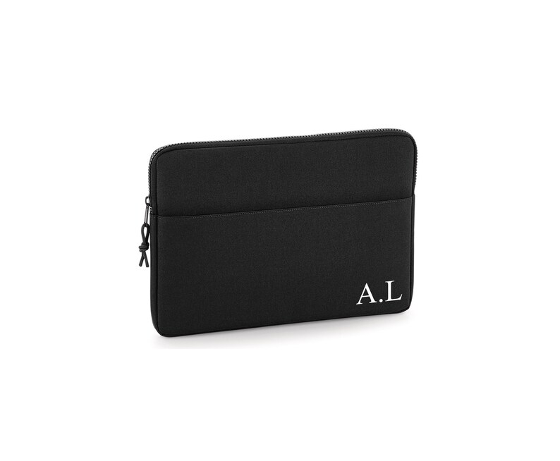 May include: Black laptop sleeve with a zipper closure and a small pocket. The initials "A.L" are printed in white on the lower right corner. The sleeve is made of a textured material.