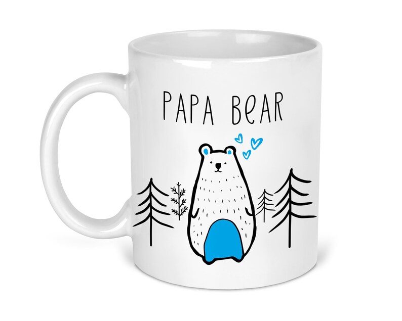 May include: White ceramic mug with a black and white illustration of a bear with blue accents. The text "Papa Bear" is printed in black on the mug.
