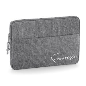 May include: Gray laptop sleeve with a zipper closure and a white embroidered name "Francesca".
