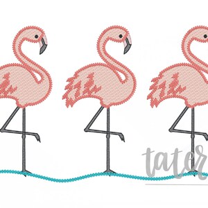 May include: Three embroidered pink flamingos with black legs and beaks stand in a row on a white background. A turquoise wavy line represents water. The text "tater + tots designs" is below the flamingos.