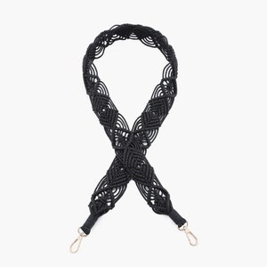 May include: Black woven strap with silver clasps. The strap is made of a thick, braided cord and has a decorative pattern.