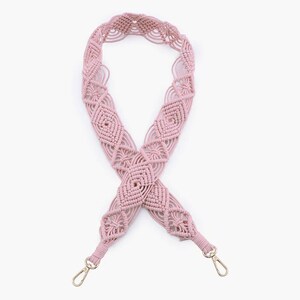 May include: A pink macrame bag strap with gold metal clasps. The strap is made of a thick, woven cord and has a geometric pattern.