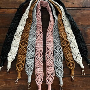 May include: A set of eight handmade macrame bag straps in various colors, including black, white, brown, gray, and pink. Each strap features a diamond pattern and has a gold metal clasp.