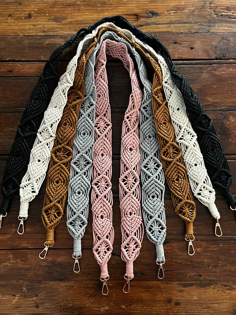 May include: A set of eight handmade macrame bag straps in various colors, including black, white, brown, gray, and pink. Each strap features a diamond pattern and has a gold metal clasp.