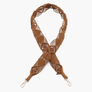 May include: A brown crocheted bag strap with a diamond pattern and silver clasps.