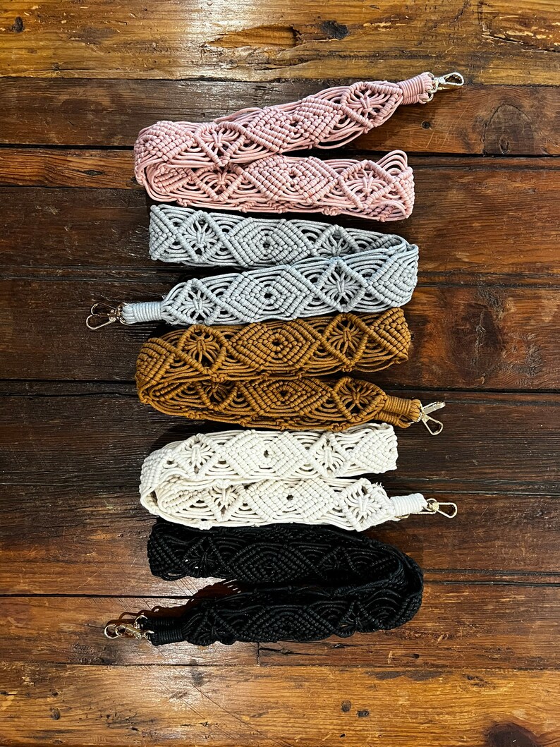 May include: Five different colored macrame straps with metal clasps. The straps are pink, gray, brown, white, and black.