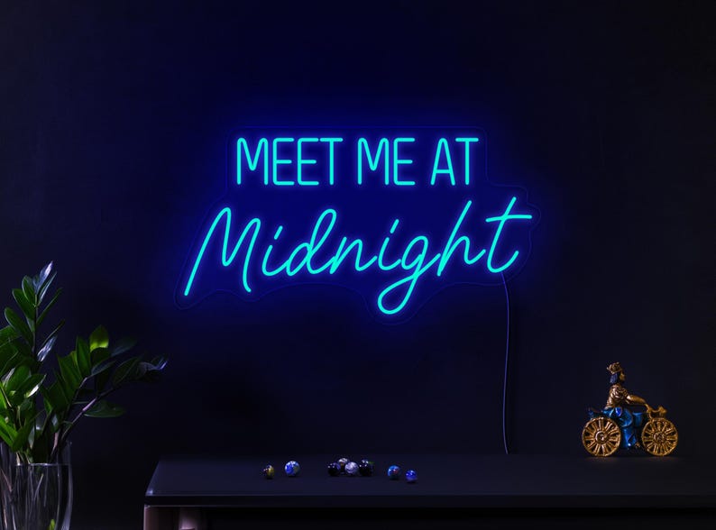 May include: Neon sign with blue light that reads "Meet Me At Midnight".