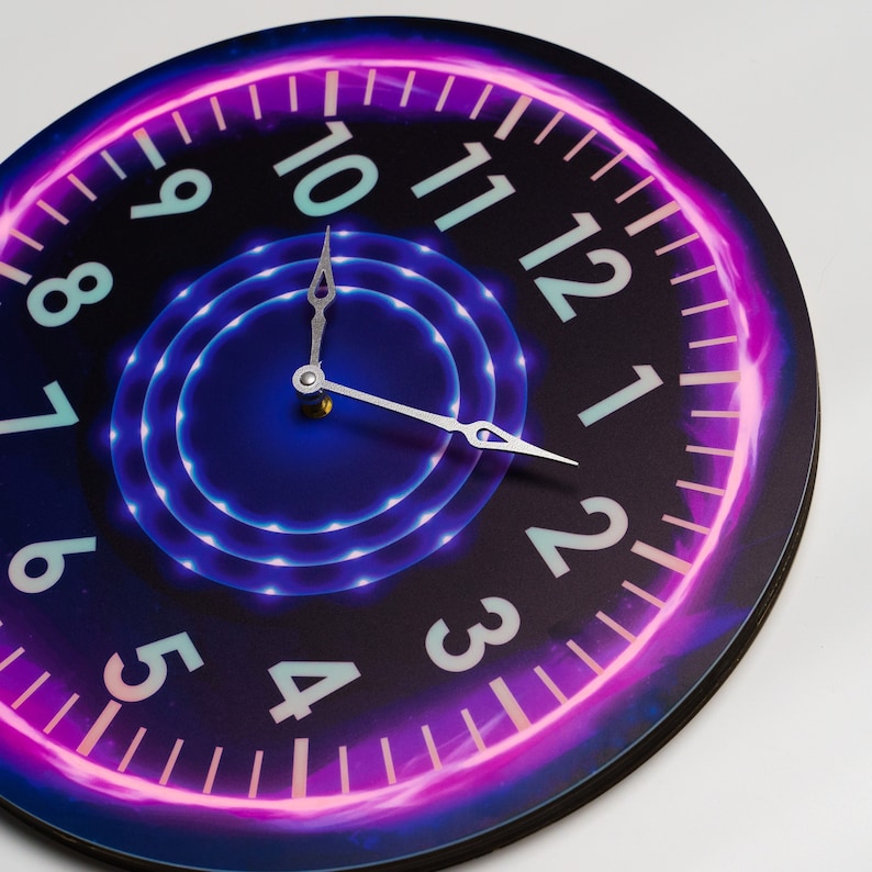 May include: A round clock with a black face and neon pink and blue accents. The clock face has white numbers from 1 to 12 and silver hands.