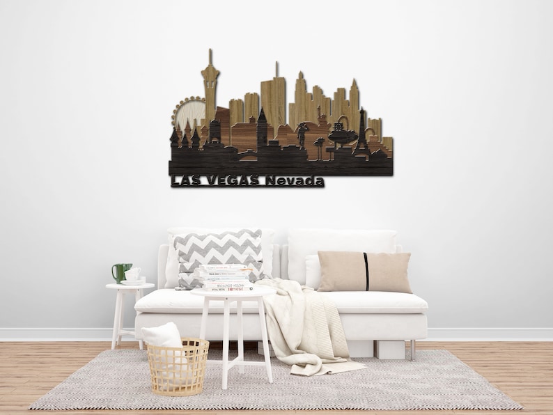 May include: Wooden wall art depicting the Las Vegas skyline with the text "Las Vegas Nevada" at the bottom. The skyline is made of different shades of brown wood and features iconic landmarks like the Eiffel Tower, the Stratosphere Tower, and the High Roller observation wheel.