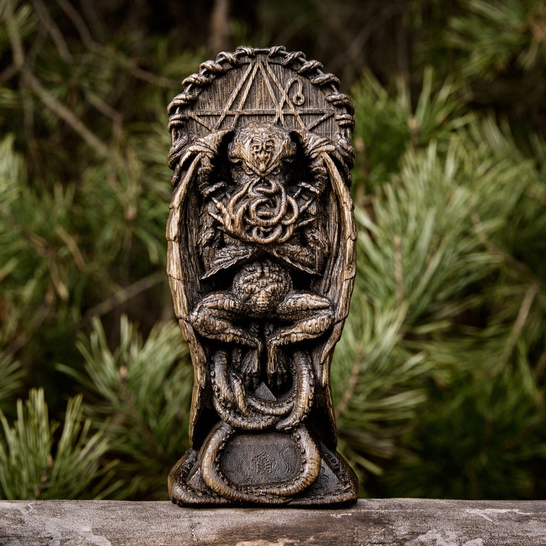 May include: A wooden statue of Cthulhu, a fictional cosmic entity from the works of H.P. Lovecraft, with tentacles and a humanoid form. The statue is carved in a dark brown wood and has a detailed design.