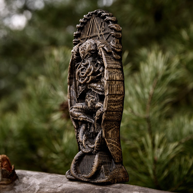 May include: A wooden carving of a creature with tentacles, resembling a Cthulhu mythos monster. The carving is detailed and intricate, with a dark brown finish. The creature is depicted sitting on a throne, with a symbol carved above it.