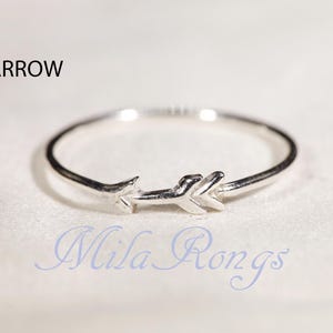 May include: A silver ring with an arrow design. The ring is simple and delicate, and the arrow is a classic symbol of love and hope.