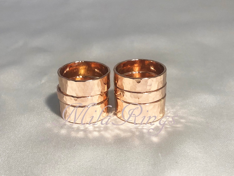 May include: Two sets of four rose gold hammered stacking rings. Each set is stacked on top of each other.