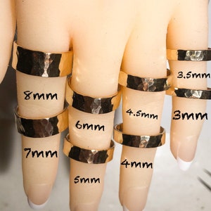 K&ouml;nnte beinhalten: Ein Set aus zehn goldenen, geh&auml;mmerten Ringen in verschiedenen Gr&ouml;&szlig;en von 3 mm bis 8 mm Durchmesser. Die Ringe werden an einem Handmodell gezeigt.