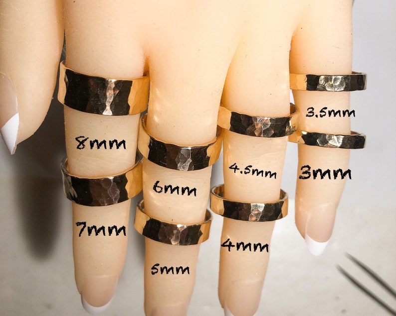 K&ouml;nnte beinhalten: Ein Set aus zehn goldenen, geh&auml;mmerten Ringen in verschiedenen Gr&ouml;&szlig;en von 3 mm bis 8 mm Durchmesser. Die Ringe werden an einem Handmodell gezeigt.