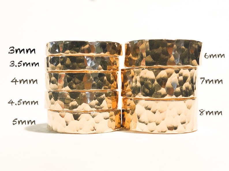 K&ouml;nnte beinhalten: Ein Satz von acht goldfarbenen, geh&auml;mmerten Metallringen, die in zwei Spalten gestapelt sind. Die Ringe sind mit ihrer Breite in Millimetern beschriftet: 3 mm, 3,5 mm, 4 mm, 4,5 mm, 5 mm, 6 mm, 7 mm und 8 mm.