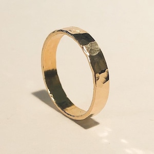 K&ouml;nnte beinhalten: Ein einfacher Goldring mit geh&auml;mmerter Textur.