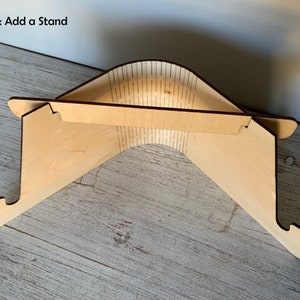 May include: A wooden laptop stand with a natural finish. The stand is folded up and ready to be used. Option: Add a Stand.