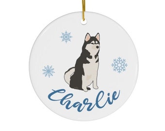 May include: White ceramic Christmas ornament with a black and white husky dog illustration, snowflakes, and the name "Charlie" in blue cursive.
