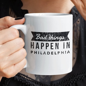 May include: White ceramic coffee mug with a black and white graphic that reads "Bad things happen in Philadelphia".