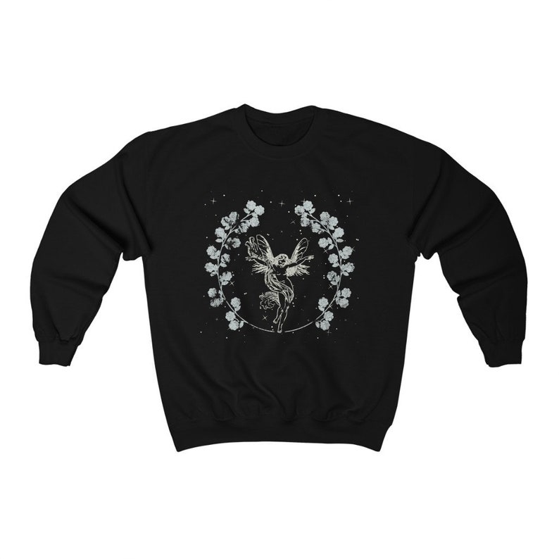 May include: Black sweatshirt with a white graphic of a fairy with wings spread, surrounded by a wreath of flowers and stars.
