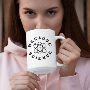 May include: White ceramic mug with a black atom graphic and the text "Because Science" around it.