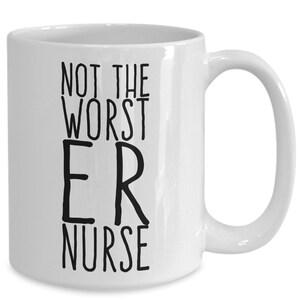May include: White ceramic coffee mug with black text that reads "Not the worst ER nurse".