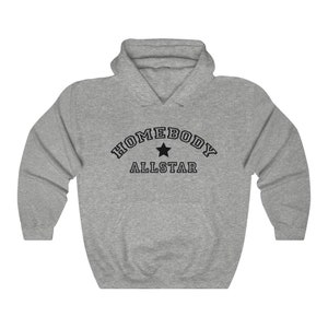 May include: A gray hooded sweatshirt with the text "Homebody Allstar" in black lettering with a black star in the center.