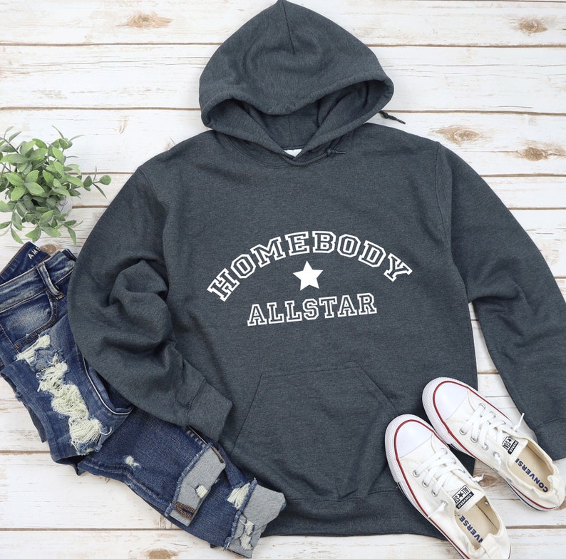 May include: A dark gray hooded sweatshirt with the text "Homebody Allstar" in white with a white star in between the words.