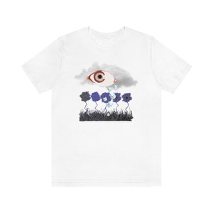 May include: White t-shirt with a graphic of a large eye inside a cloud crying blue teardrops onto a field of blue flowers.