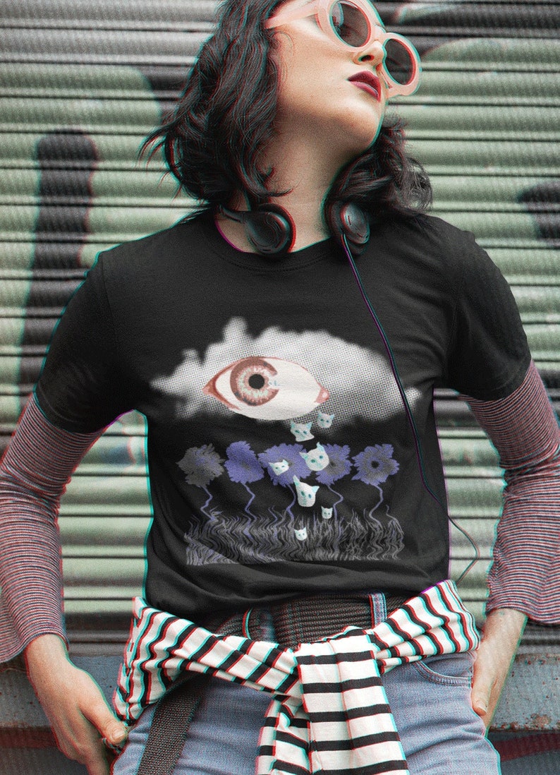 May include: A black t-shirt with a graphic of a large eye in a cloud raining cats. The graphic is in a glitch style with a blue and purple color scheme.