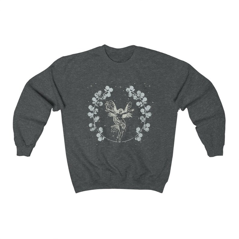 May include: A dark heather grey sweatshirt with a white graphic of a fairy flying inside a wreath of flowers.