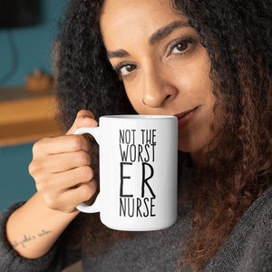 May include: White ceramic mug with black text that reads "Not the worst ER nurse".