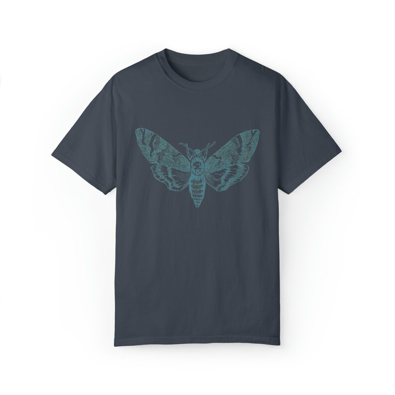 May include: A dark blue t-shirt with a teal and blue graphic of a moth with wings spread.