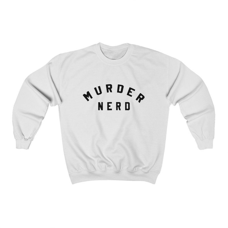 May include: White sweatshirt with black text that reads "MURDER NERD" in an arched font.