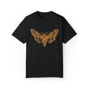 May include: A black t-shirt with an orange graphic of a moth.