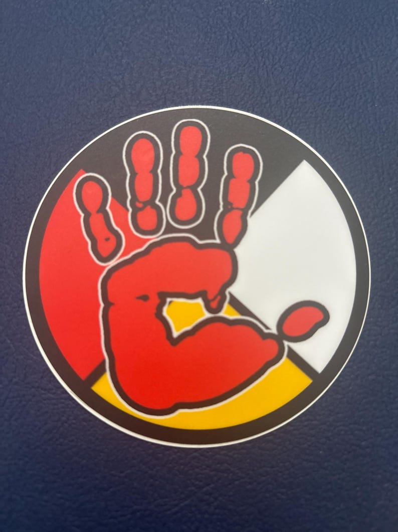 May include: A red handprint inside a circle with four colors: red, black, white, and yellow. The colors represent the four directions and the four races of humanity.