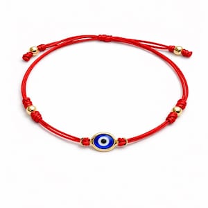 May include: Red cord bracelet with a gold-coloured evil eye charm with a blue centre. The bracelet has gold-coloured beads and adjustable knots. A simple, yet elegant piece of jewellery.