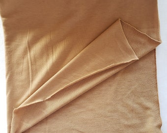 May include: A folded piece of brown fabric with a smooth texture on one side and a textured surface on the other side.