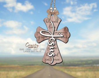 May include: A wooden cross with the word "Jesus" in white lettering and the words "blessed, love, patience, grace, peace, and love" surrounding it. The cross is hanging from a string with a bow.