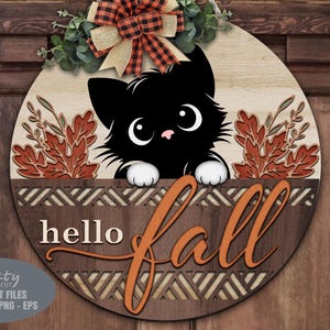 May include: A wooden round sign with a black cat peeking over a decorative border. The sign says "hello fall" in orange script. The sign is decorated with fall leaves and a plaid bow.