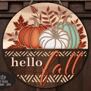 A Floral Pumpkin Welcome Sign SVG Laser Cut File with a Hello Fall Door Hanger SVG theme including a trio of pumpkins and fall leaves in a basket for use with your Glowforge, XTool and other laser machines.