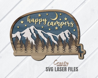 May include: A laser cut wooden camper design with a blue and brown woodgrain finish. The camper has a mountain scene with a crescent moon and stars. The text "happy campers" is written in gold lettering.