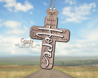 May include: A wooden cross with the word "Hope" written in white script on it. The cross is decorated with the words "love", "peace", and "good will" written in a cursive font. The cross is hanging from a string with a brown bow.