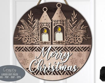Puede incluir: Un letrero redondo de madera con fondo marrón y una inscripción blanca "Merry Christmas". El letrero presenta un diseño decorativo de dos linternas con velas, ramas de pino y copos de nieve.