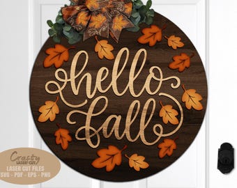 May include: A round wooden sign with the words "hello Fall" in a cursive font. The sign is decorated with orange leaf cutouts and a decorative bow. The sign is approximately 12 inches in diameter.